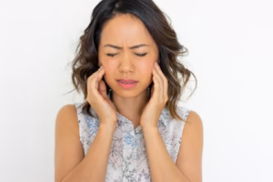 Woman holding her face, looking concerned.