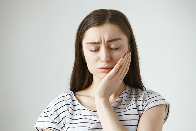 portrait unhappy depressed young caucasian brunette woman closing eyes frustration pressing hand against cheek trying soothe pain while suffering from toothache having tooth decay 3