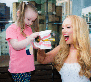 Child practicing dental hygiene demonstration.