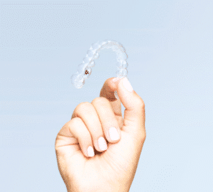 Hand holding clear Invisalign aligner