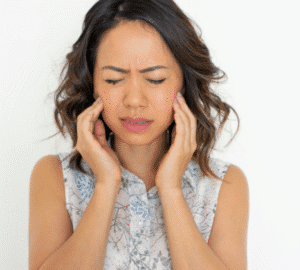 Woman holding her face, looking concerned.
